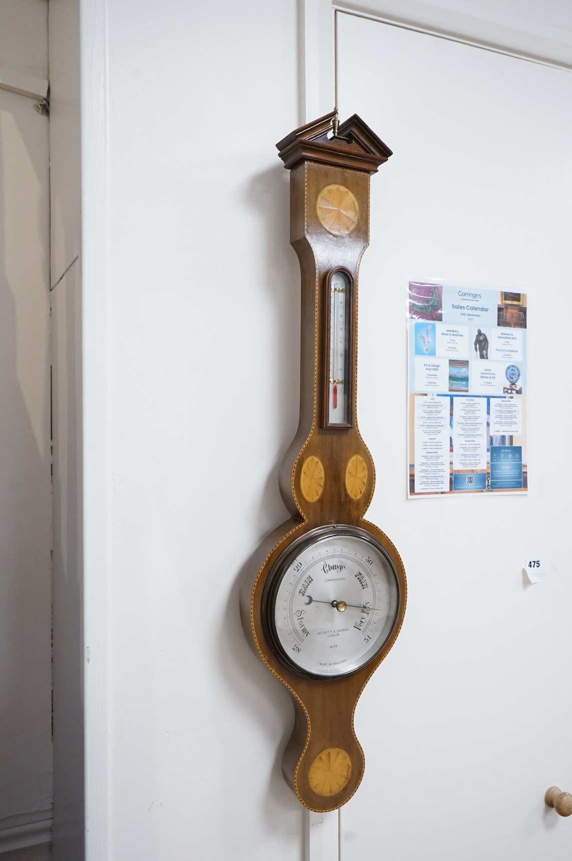 An Edwardian style inlaid mahogany Negretti & Zambra wheel barometer / thermometer, 82cm high